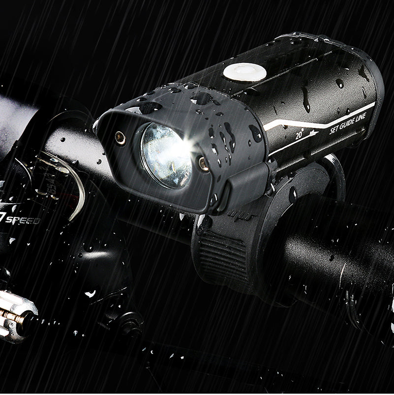 Bicycle light on a bike handlebar with raindrops, brand 'Speed' visible